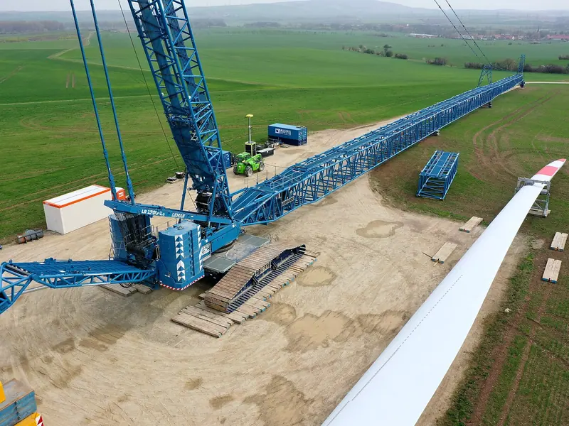 Crawler crane with a long lattice boom being assembled on an open site