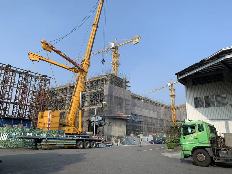 Large all-terrain mobile crane lifting an aerial work platform