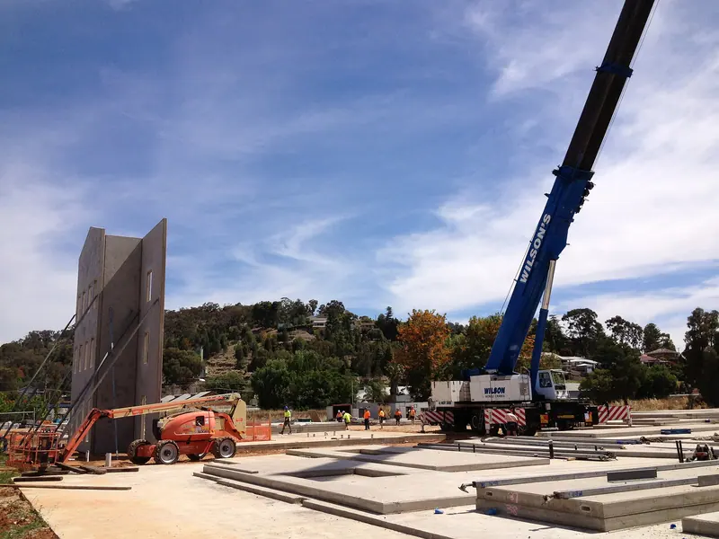Mobile crane lifting precast concrete wall panels into place